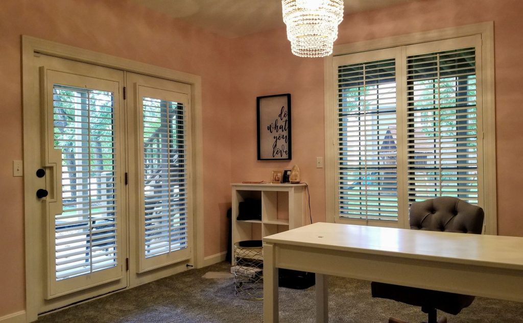 Cozy home office with French doors and chandelier.