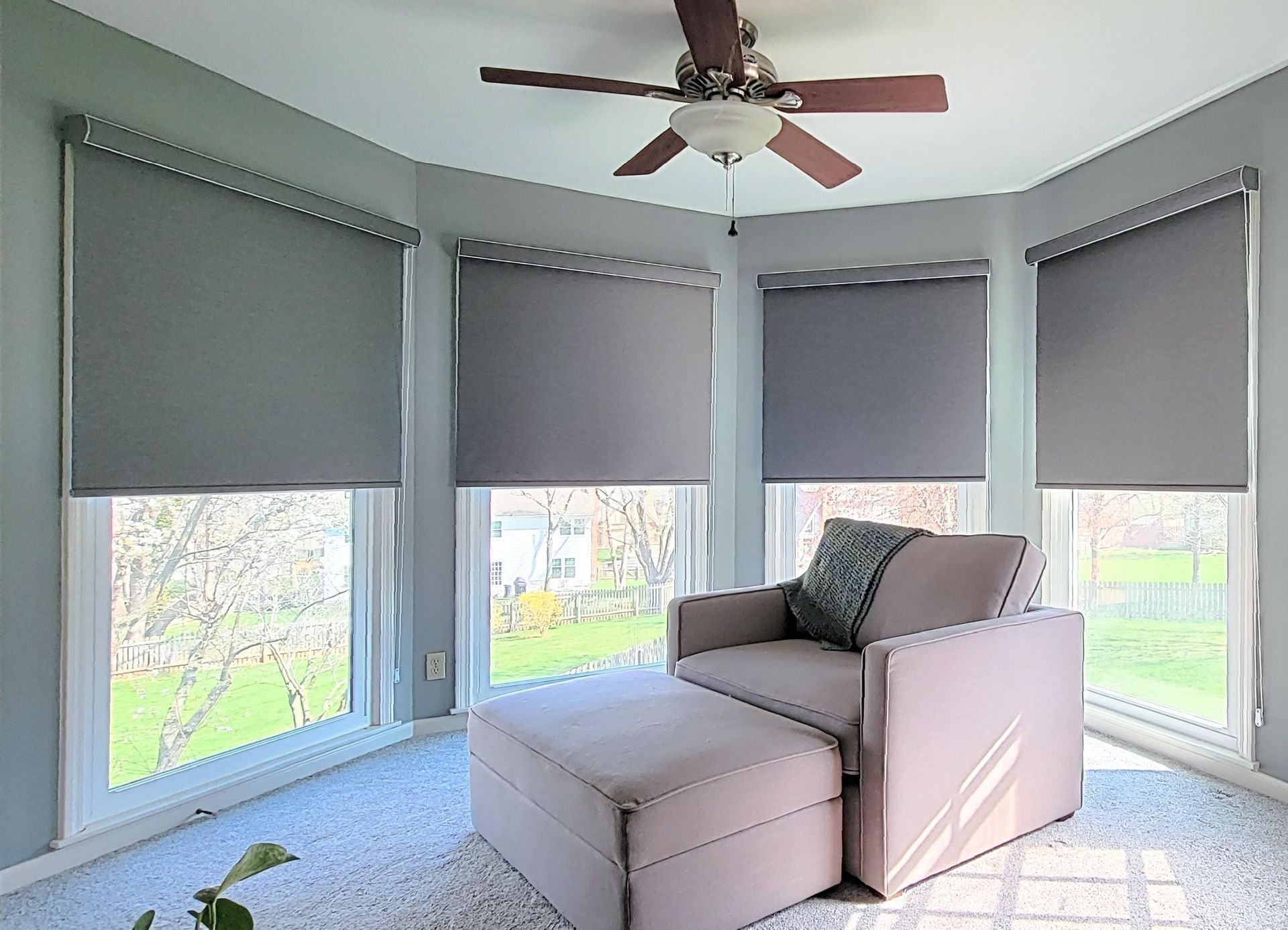 Cozy room with armchair and roller shades.