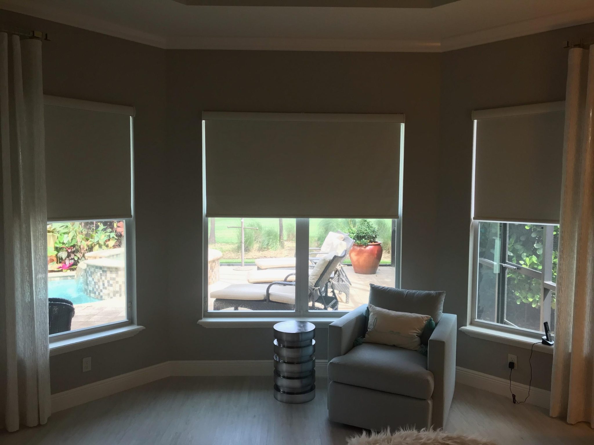 Cozy room with large shaded windows and chair