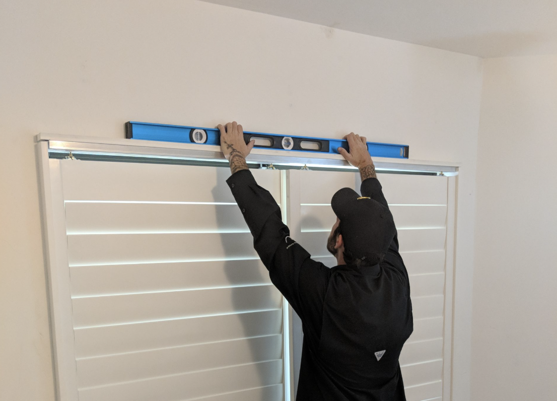 Person using level on window frame