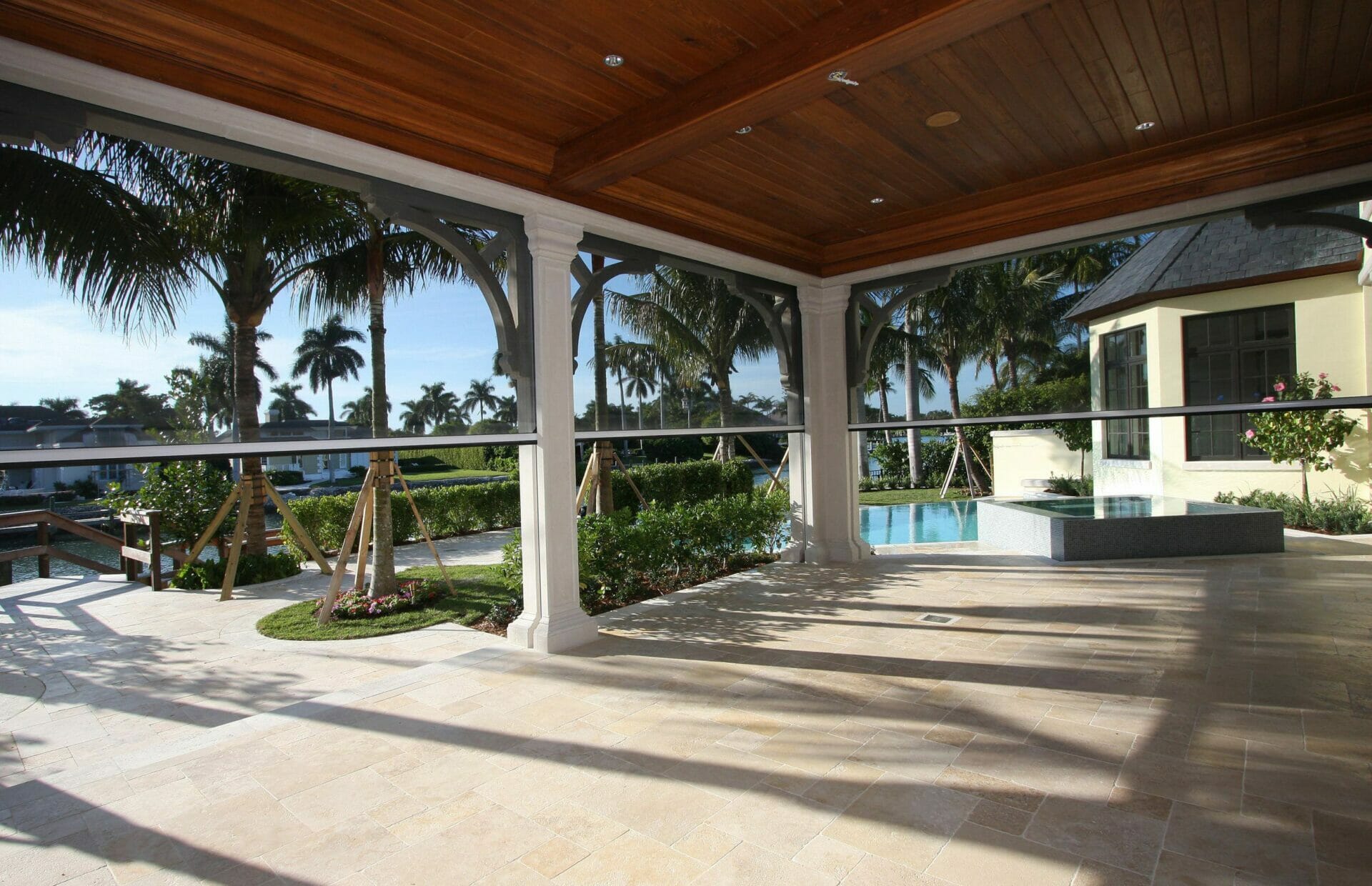 Poolside patio with retractable shades and palm trees