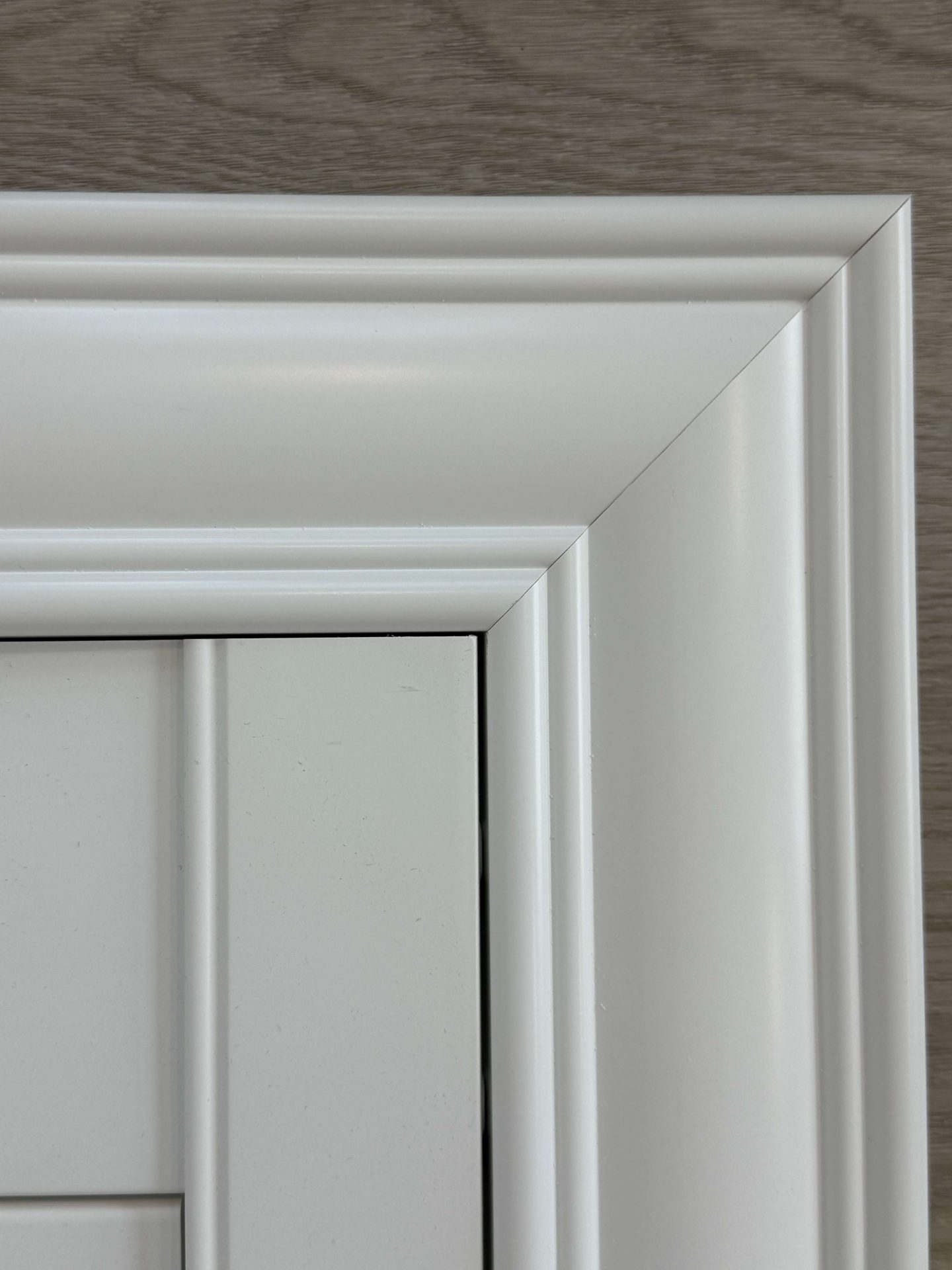 White decorative picture frame on wooden surface.